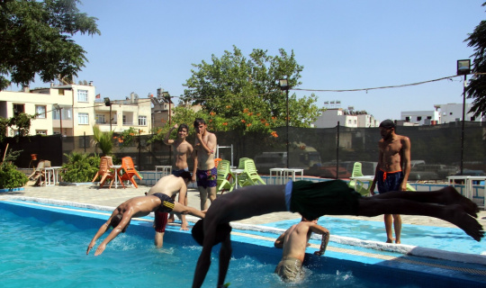 Aşırı sıcaktan bunalan gençler havuzda serinliyor