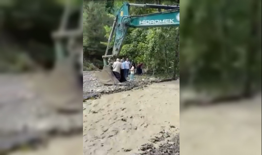 Çayın karşısına geçmeye isteyen vatandaşları kepçe taşıdı
